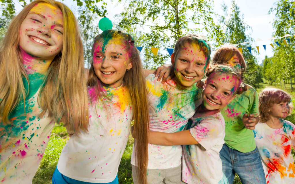 A group of kids covered in paint having fun.