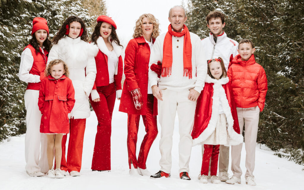 A Celtic Family Christmas promo with a family in red and white clothes with pine trees in the backgrounds.