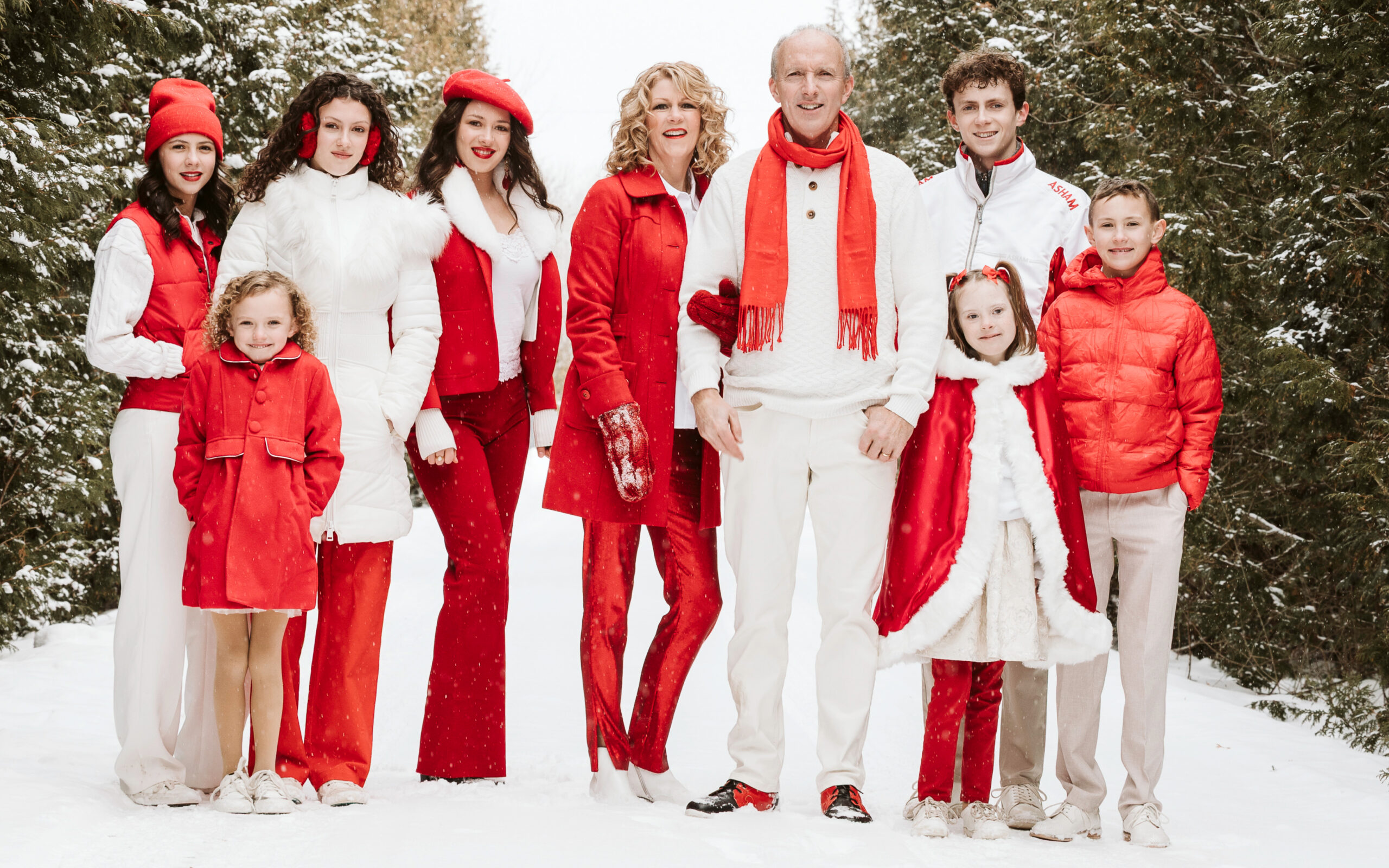 A Celtic Family Christmas promo with a family in red and white clothes with pine trees in the backgrounds.