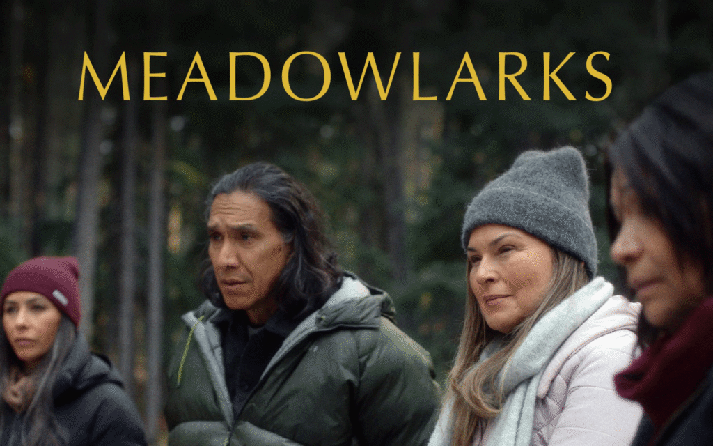 Four people standing together in winter coats and hats with the word Meadowlarks.